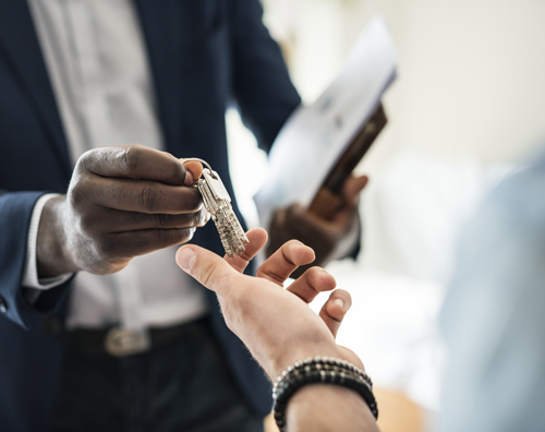 Real estate agent handing the house key to a client